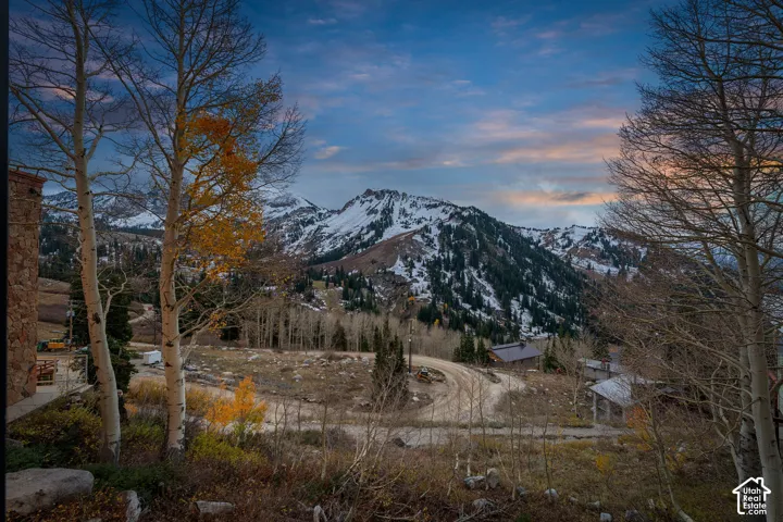 Mountain landscape featuring snow-capped peaks, mature aspen trees, and stone exterior siding