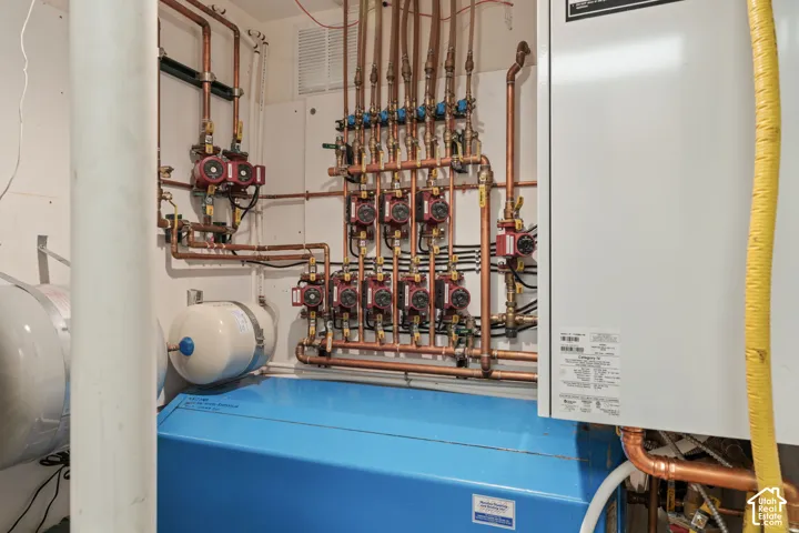 Hydronic heating system featuring a high-efficiency boiler, multi-zone copper piping, circulation pumps, and an expansion tank