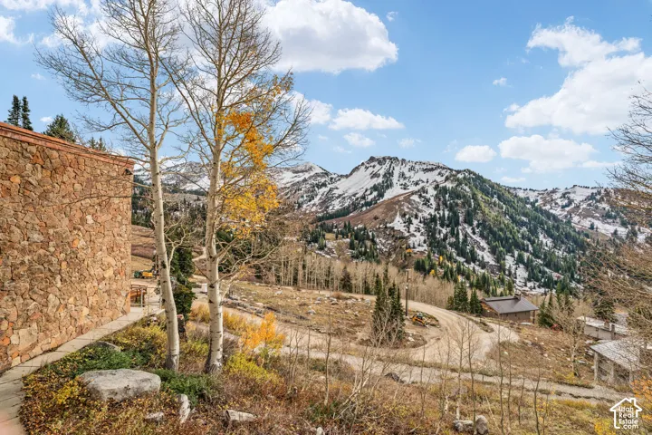 Exterior facade featuring natural stone masonry, mature aspen trees, and expansive mountainous terrain