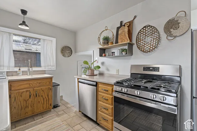Chef's kitchen featuring stainless steel gas range with multiple burners, stainless steel dishwasher, and wood-finish cabinetry