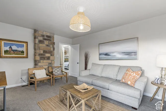 Woven pendant light fixture, stone-clad architectural element, light gray wall paint, and gray carpeting