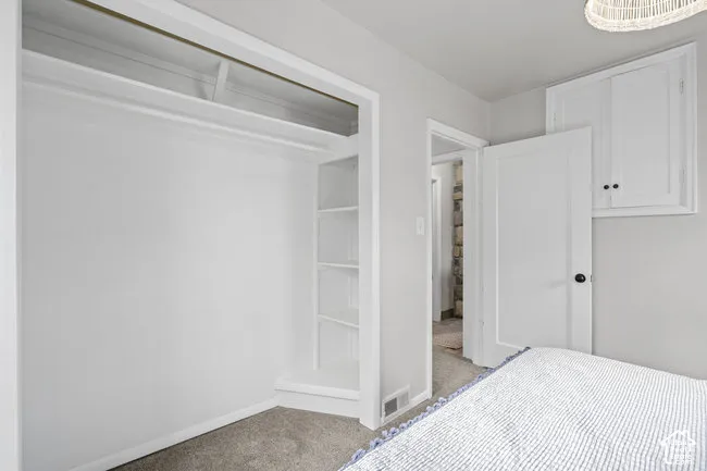 Built-in closet shelving, integrated storage cabinet, recessed lighting fixture, light gray wall paint, and white trim