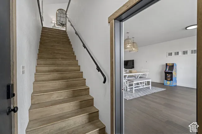 Elegant wooden staircase with natural wood treads and metal handrail leading to upper level