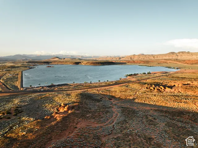 Aerial perspective of reservoir bordered by high-desert terrain and mountain backdrop