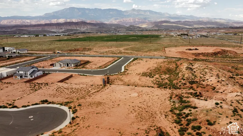 Expansive desert land parcel featuring mountain range scenery, native topography, paved street access, and utility-ready infrastructure