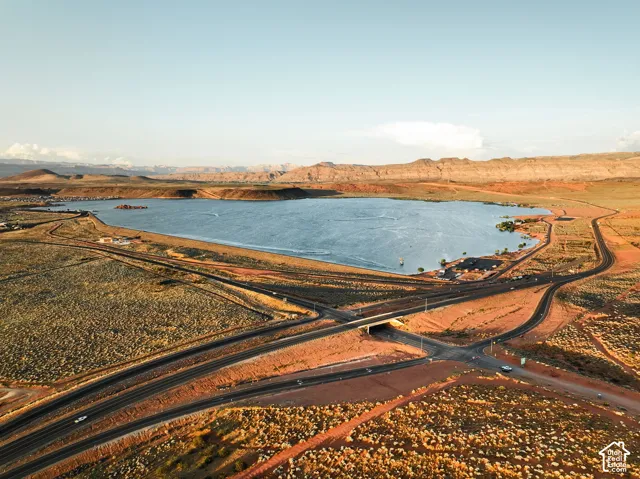 Aerial landscape featuring high-desert topography, a natural reservoir, and distant mountain ranges