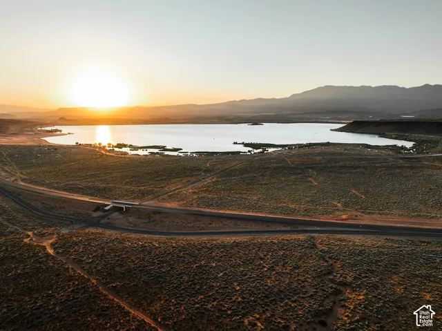 Aerial perspective of expansive high-desert landscape featuring a natural reservoir and mountain range backdrop