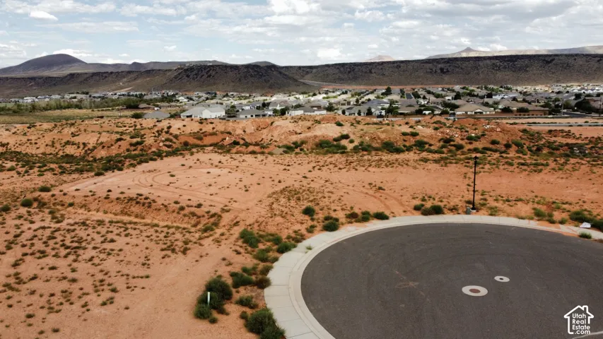 Vacant lot situated in a cul-de-sac, featuring native desert terrain and mountain backdrops