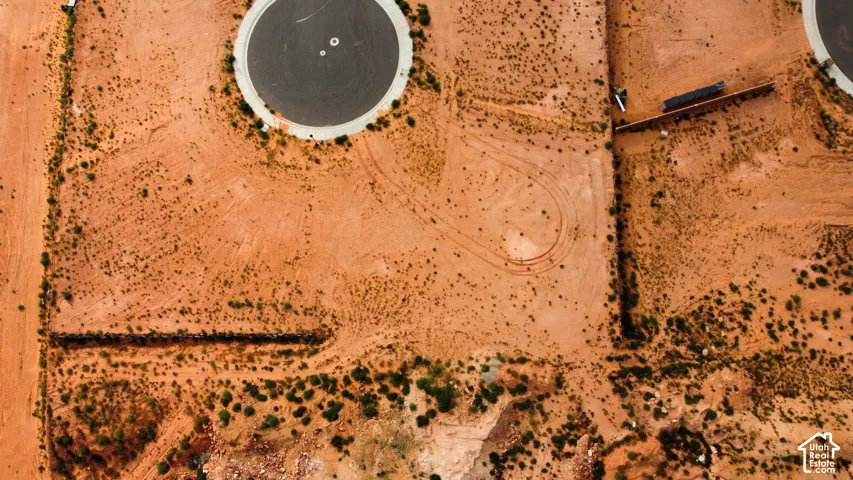 Vacant parcel featuring desert terrain, native vegetation, and established retaining walls, positioned at the edge of a paved cul-de-sac