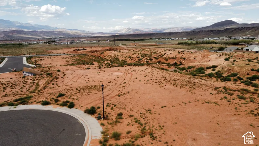 Expansive lot featuring paved cul-de-sac frontage, installed street lamp, and prominent mountain range backdrop