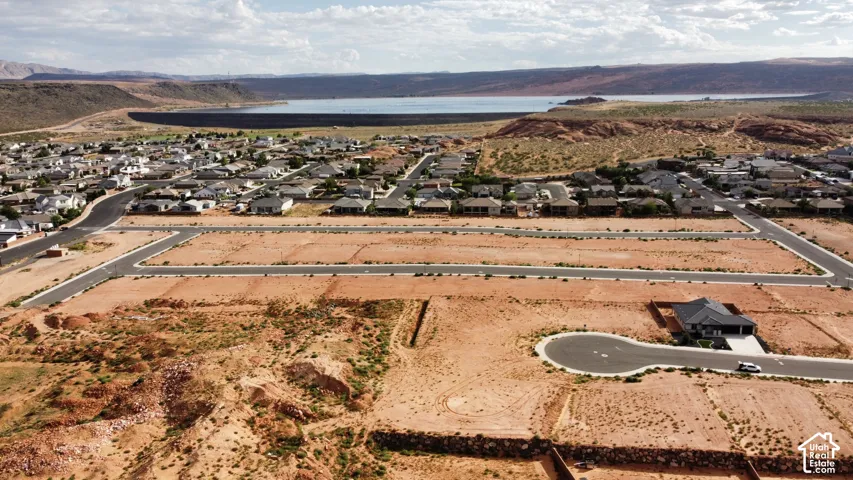 Undeveloped residential lots featuring paved roads, infrastructure, and proximity to a reservoir backdrop