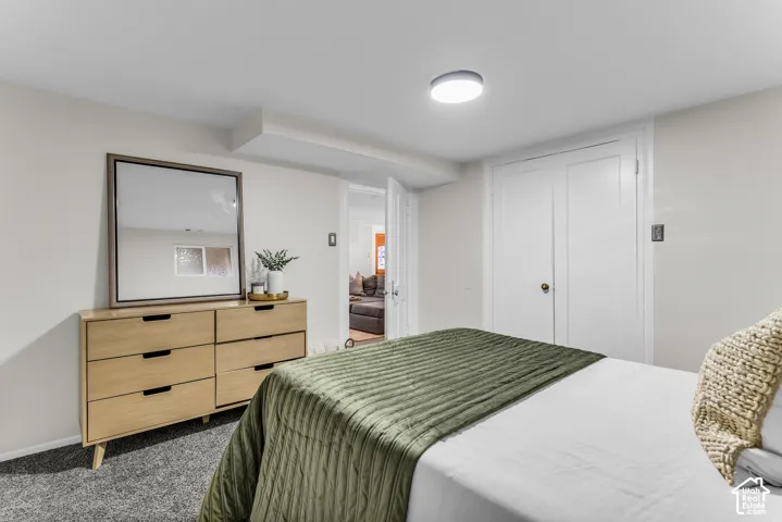 Neutral interior walls, carpeted flooring, double-door closet, and flush-mount ceiling lighting