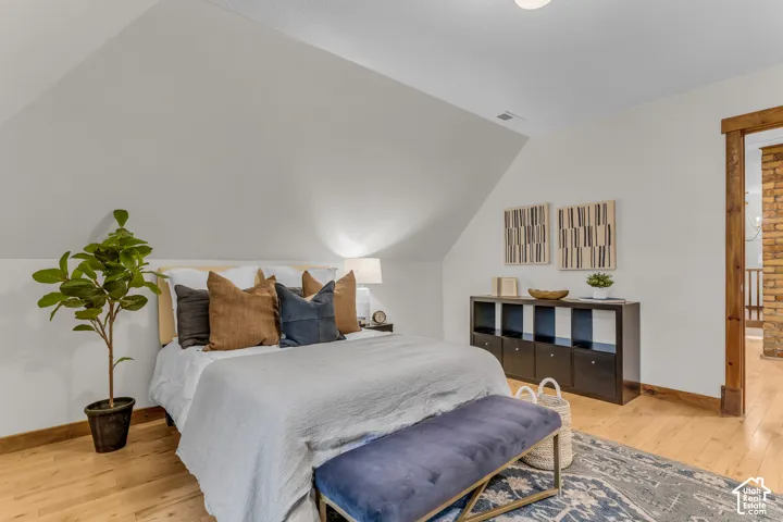 Vaulted ceilings, wood-finish flooring, and natural wood door casing