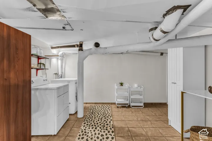 Laundry area featuring large-format ceramic tile flooring, built-in floor-to-ceiling storage cabinetry, and open wall-mounted shelving