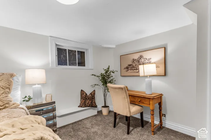 Neutral-toned interior space featuring recessed, casement-style window with white trim, built-in lower-wall niche, and plush wall-to-wall carpeting
