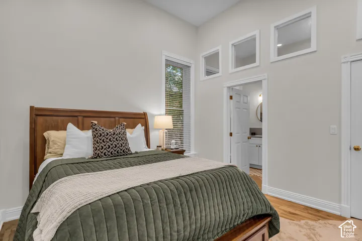 Vaulted ceilings with clerestory windows, wood-finish flooring, and crisp white millwork surrounding doorway transitions