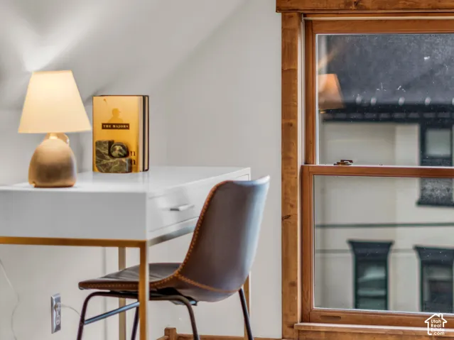 Sloped ceilings, natural wood-trimmed window casing, and wood-finish flooring