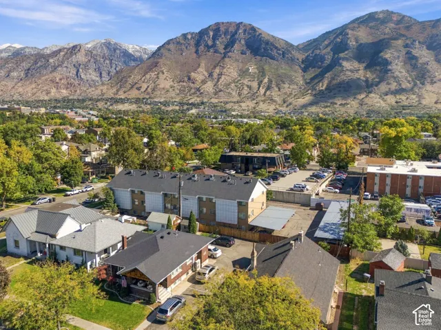 Aerial perspective showcasing established residential neighborhood featuring mature trees and expansive mountain backdrop