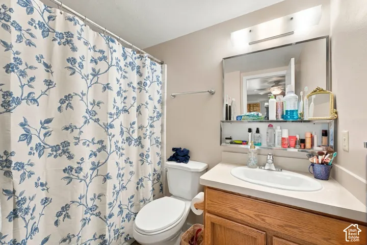 Bathroom featuring a wood-finish vanity, integrated countertop with an oval basin, chrome faucet, mirrored medicine cabinet with integrated shelving, and a wall-mounted light fixture