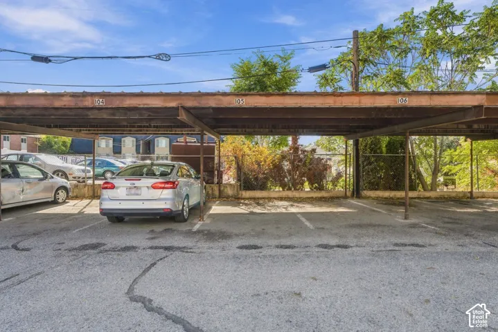 Covered parking structure featuring numbered stalls and metal roofing