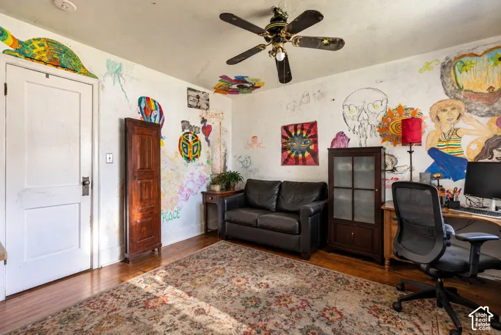 Room featuring wood-finish flooring and a ceiling-mounted fan with integrated lighting  (Photo has been virtually decluttered)