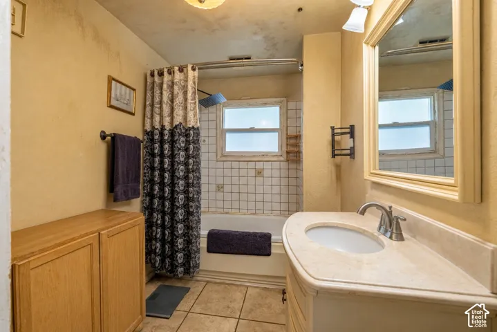Bathroom featuring a vanity with a stone-top counter, undermount sink, and metallic faucet hardware  (Photo has been virtually decluttered)