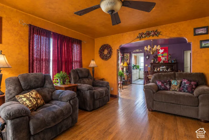 Wood-finish flooring, textured wall finishes, arched doorway, and ceiling-mounted fan  (Photo has been virtually decluttered)