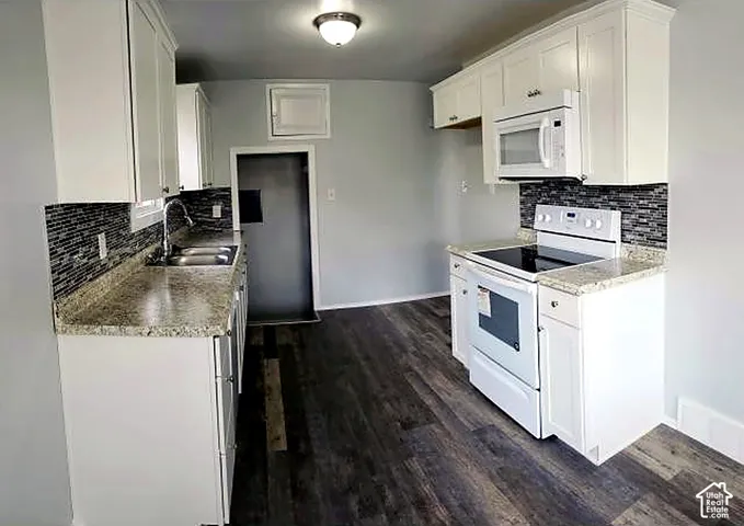 Upper unit kitchen. Range, tile backsplash and luxury vinyl plank flooring.