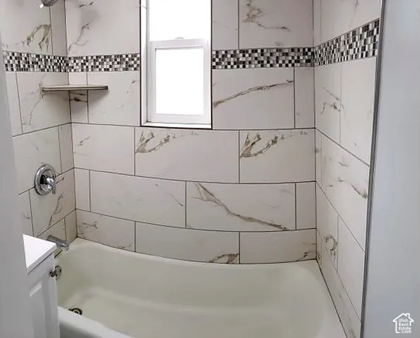 Lower unit full bathroom with tiled tub surround.