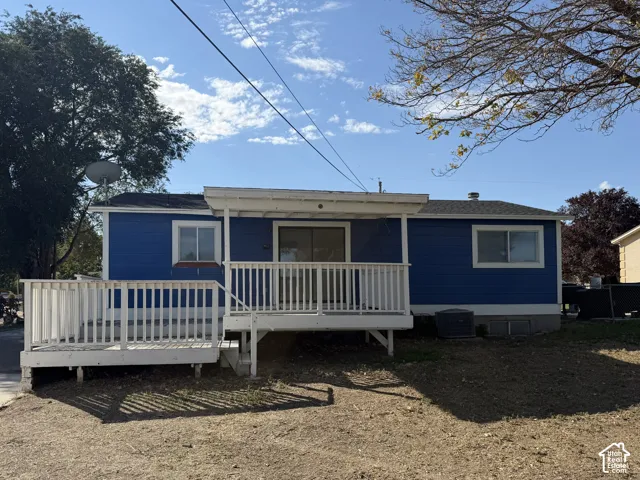 Exterior featuring blue horizontal siding, white wooden deck with railing, sliding glass door, and sliding windows