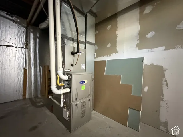Carrier furnace unit with metal ductwork and PVC piping installed in an unfinished utility space