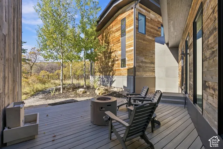 Private exterior zen deck featuring water feature and fire pit