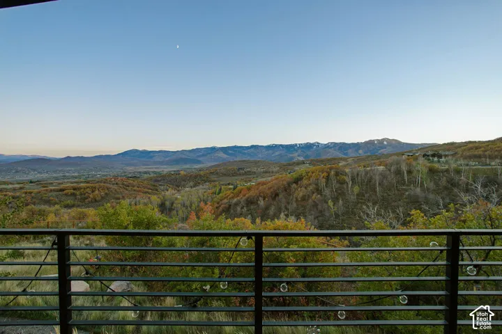 Elevated deck featuring black metal horizontal railings and expansive mountain and hillside terrain scenery