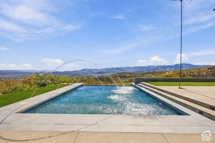 Beautiful private patio with custom infinity-edge pool, fire place, and views of the Uinta Range, Deer Valley, Park City and Wasatch Back