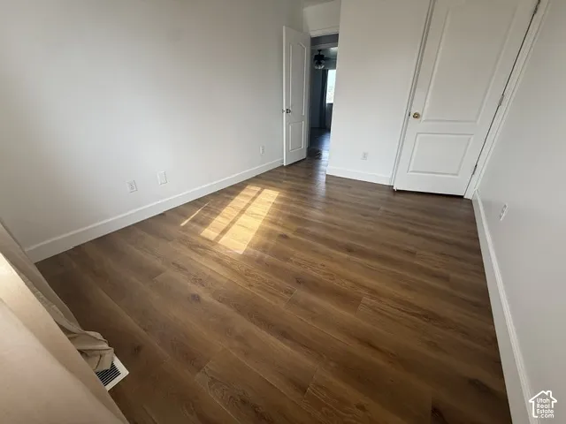 Interior space featuring wood-finish flooring, crisp white walls, and two-panel interior doors