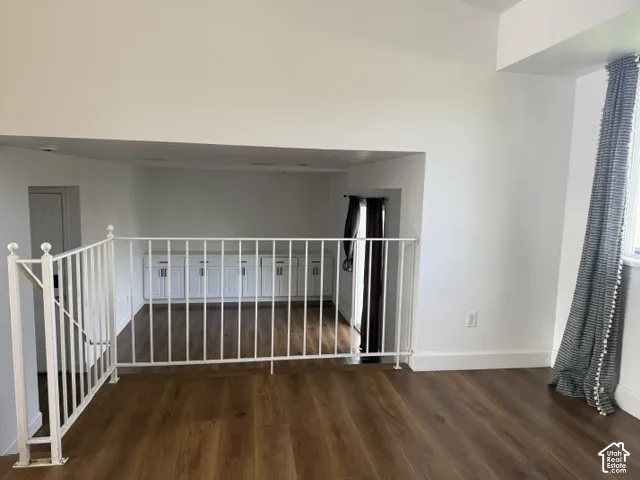 Multi-level interior featuring wood-finish flooring, white metal balustrade railing, and built-in white cabinetry