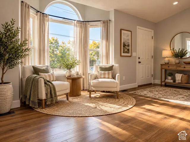 Bay window featuring a prominent arched transom, wood-finish flooring, and a six-panel entry door
