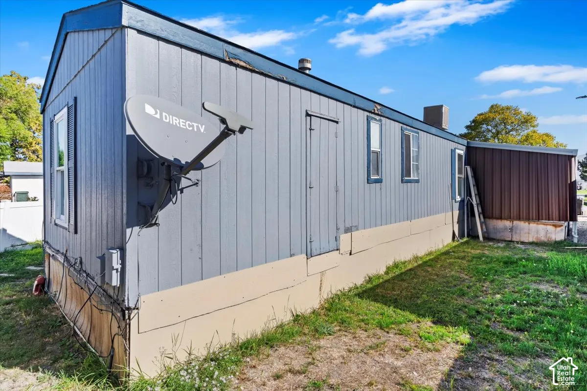 Vertical wood-panel siding with two-tone finish, metal roof structure, and perimeter foundation skirting