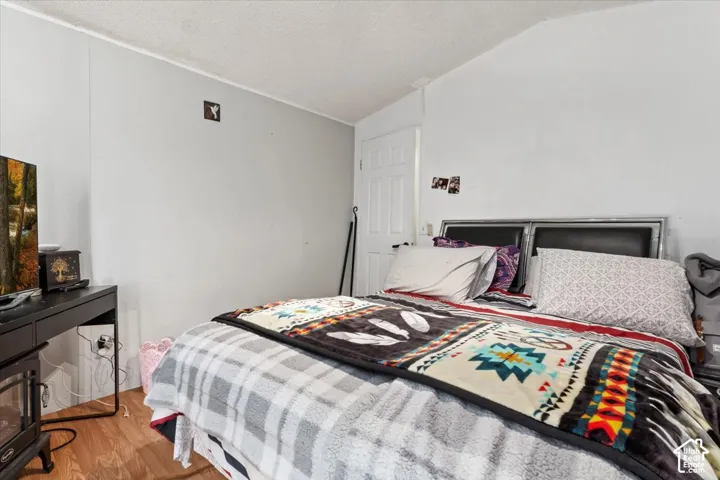 Room featuring wood-finish flooring, a neutral wall finish, and a six-panel interior door