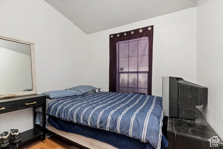 Room featuring neutral walls, a multi-pane window, and wood-finish flooring
