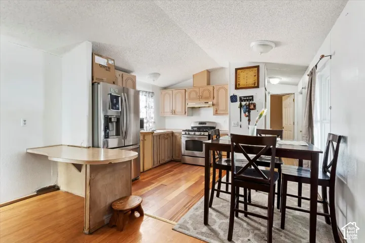 Kitchen featuring wood-finish flooring, stainless steel appliances, and wood cabinetry