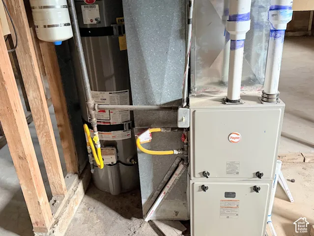 Gas-powered water heater and Payne forced-air furnace unit with metal ductwork and PVC piping
