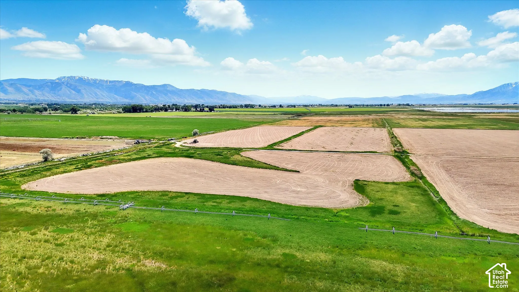 Expansive acreage featuring open fields, an irrigation system, and prominent mountain backdrops