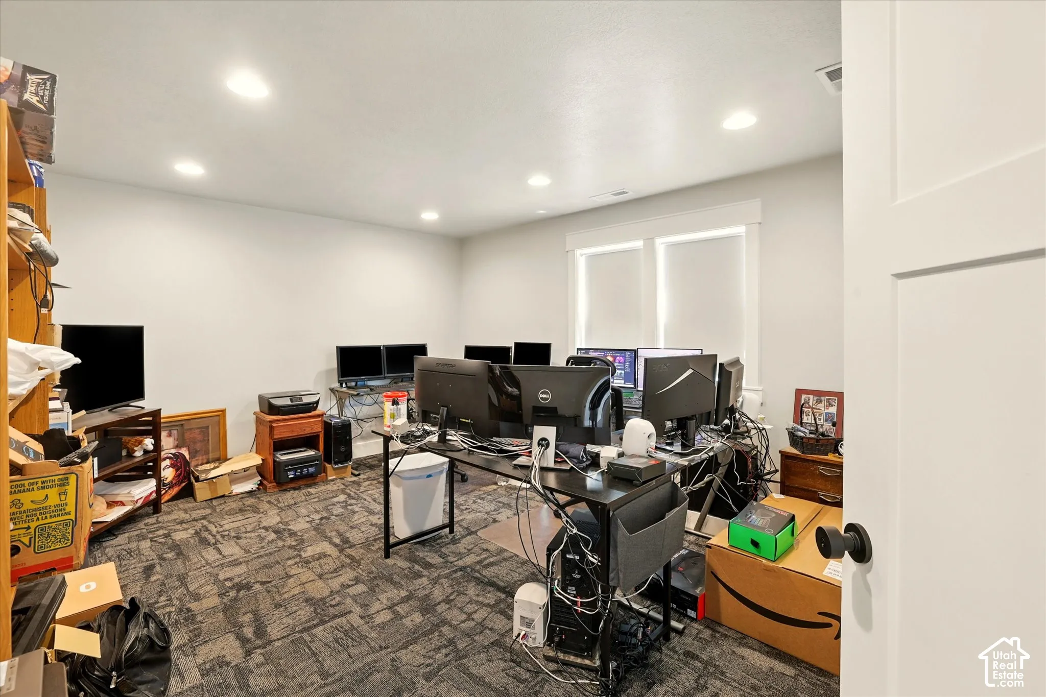 Interior room featuring recessed ceiling lighting, patterned carpeting, and dual-pane windows with thick trim casing (office or bedroom)