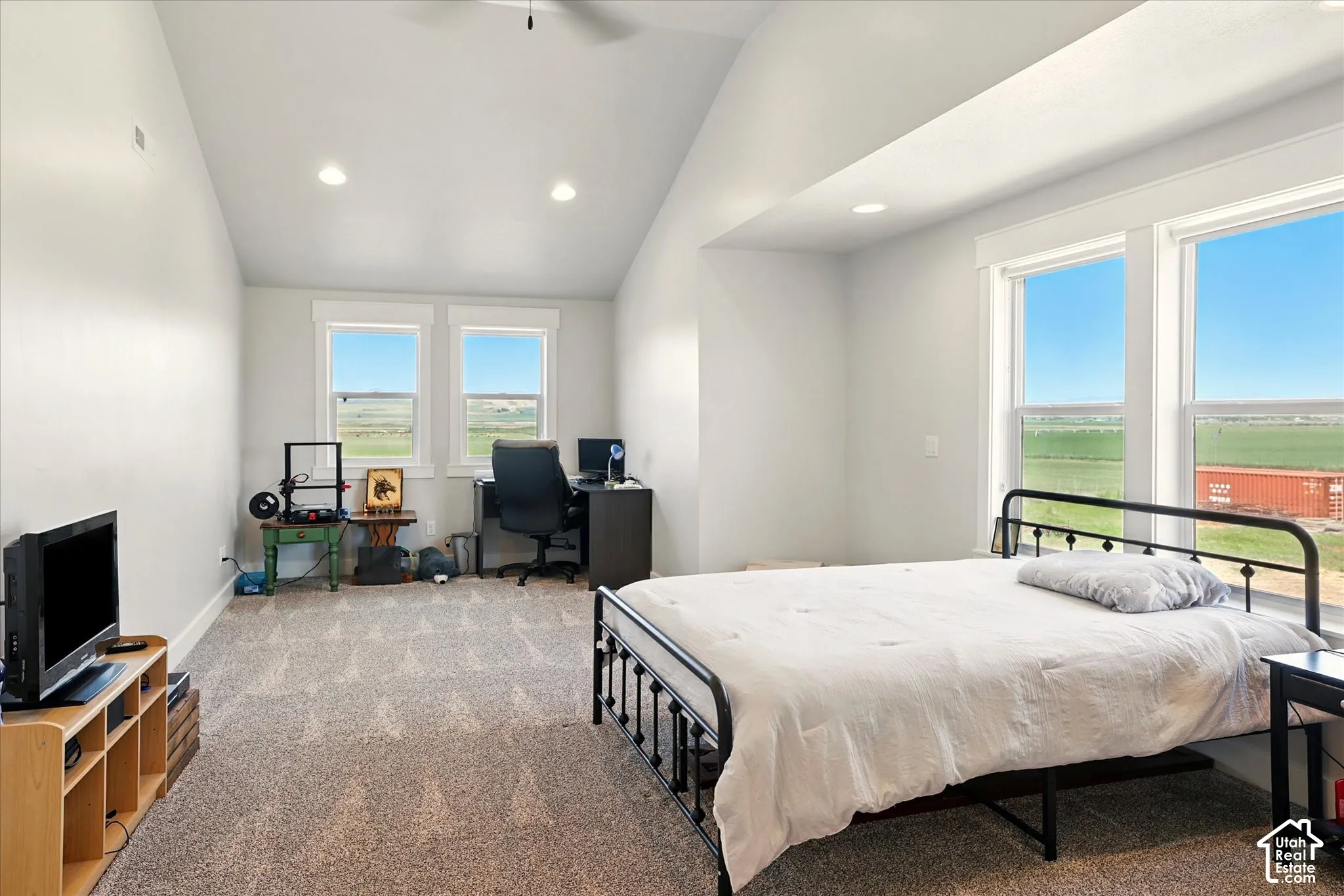 Vaulted ceilings, neutral carpeting, recessed lighting, and large windows providing natural light and exterior scenery