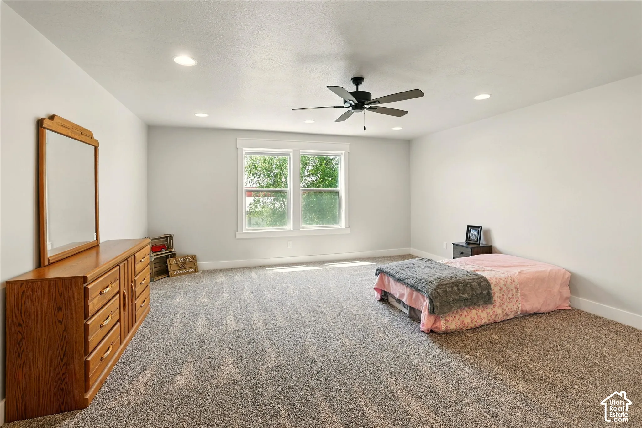 Neutral-toned wall paint, recessed lighting, carpeted flooring, and a ceiling fan