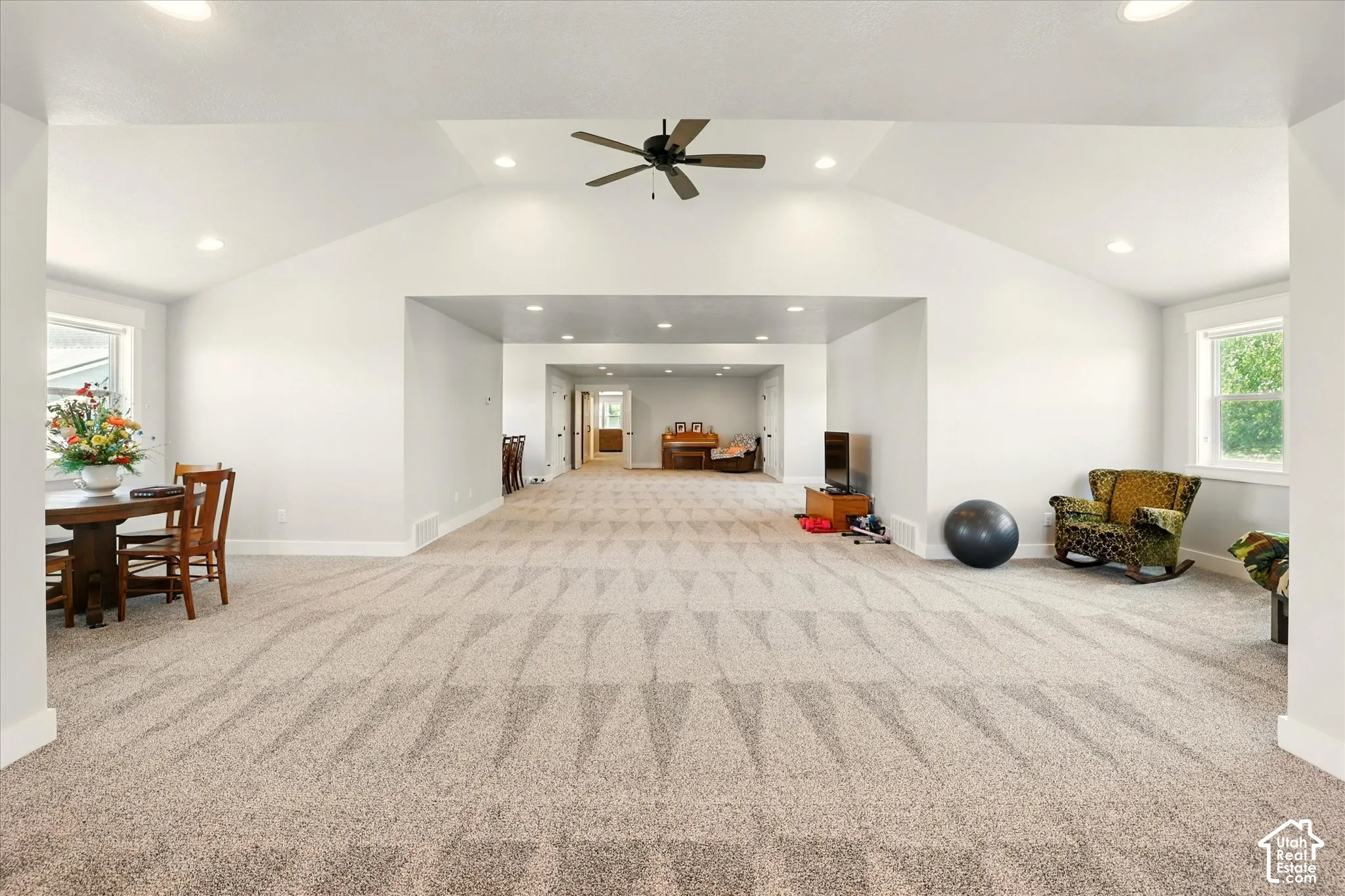 Expansive bonus room featuring a vaulted ceiling, recessed lighting, neutral carpeting, and a central ceiling fan