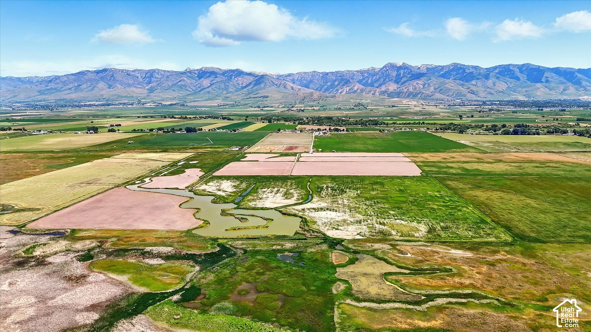 Expansive acreage featuring natural water channels, open terrain, and mountain range backdrop