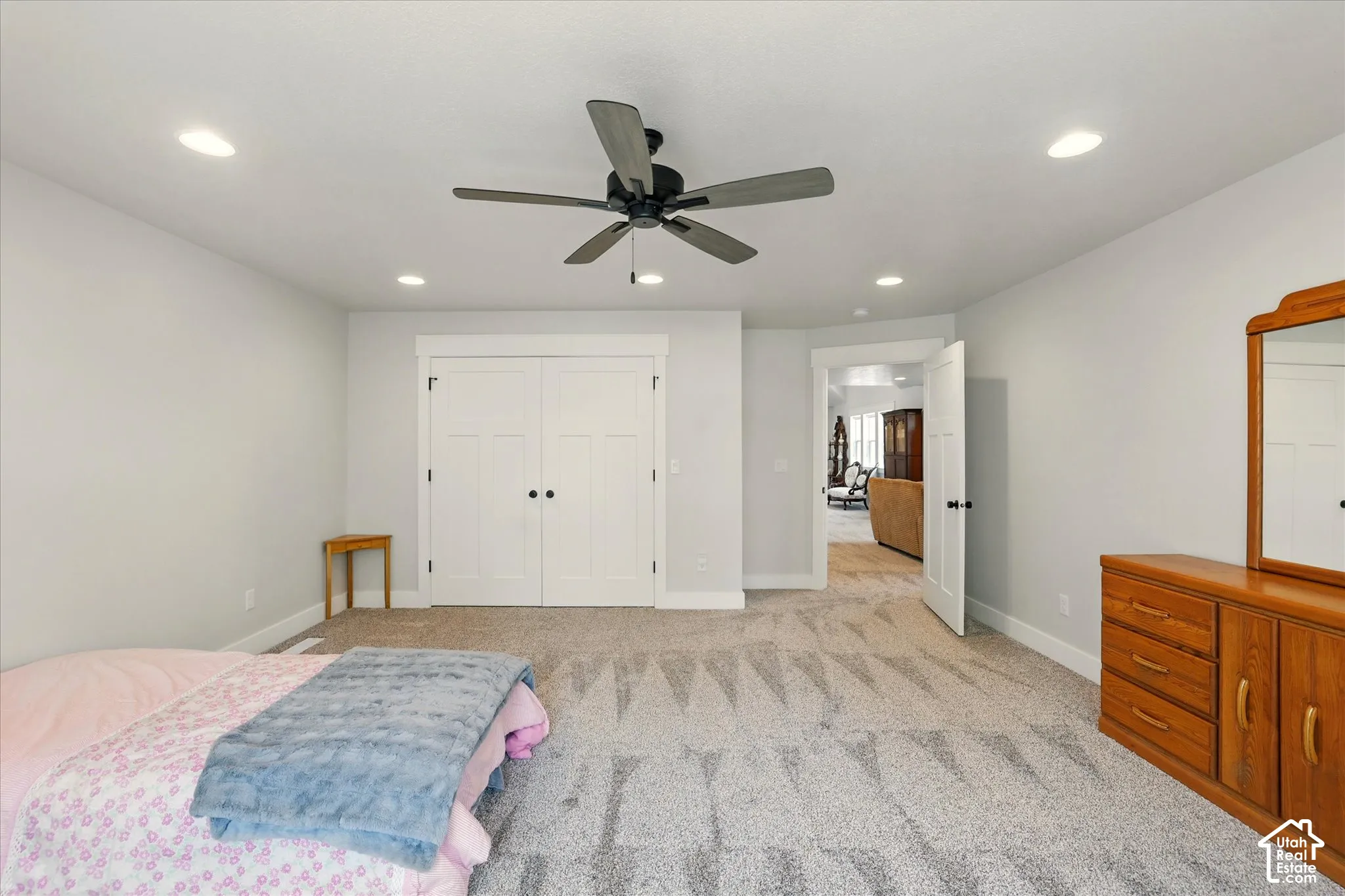 Neutral-toned interior featuring recessed lighting, a multi-blade ceiling fan, wall-to-wall carpeting, and double-panel closet doors with matte black hardware