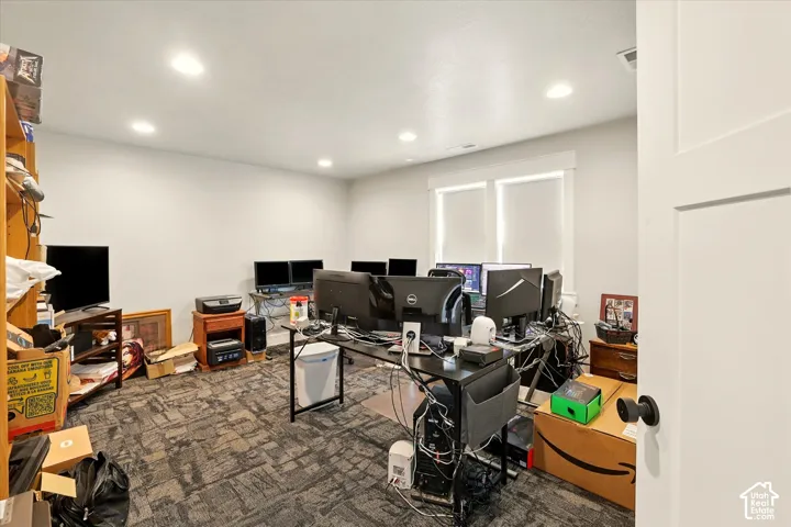 Interior room featuring recessed ceiling lighting, patterned carpeting, and dual-pane windows with thick trim casing (office or bedroom)
